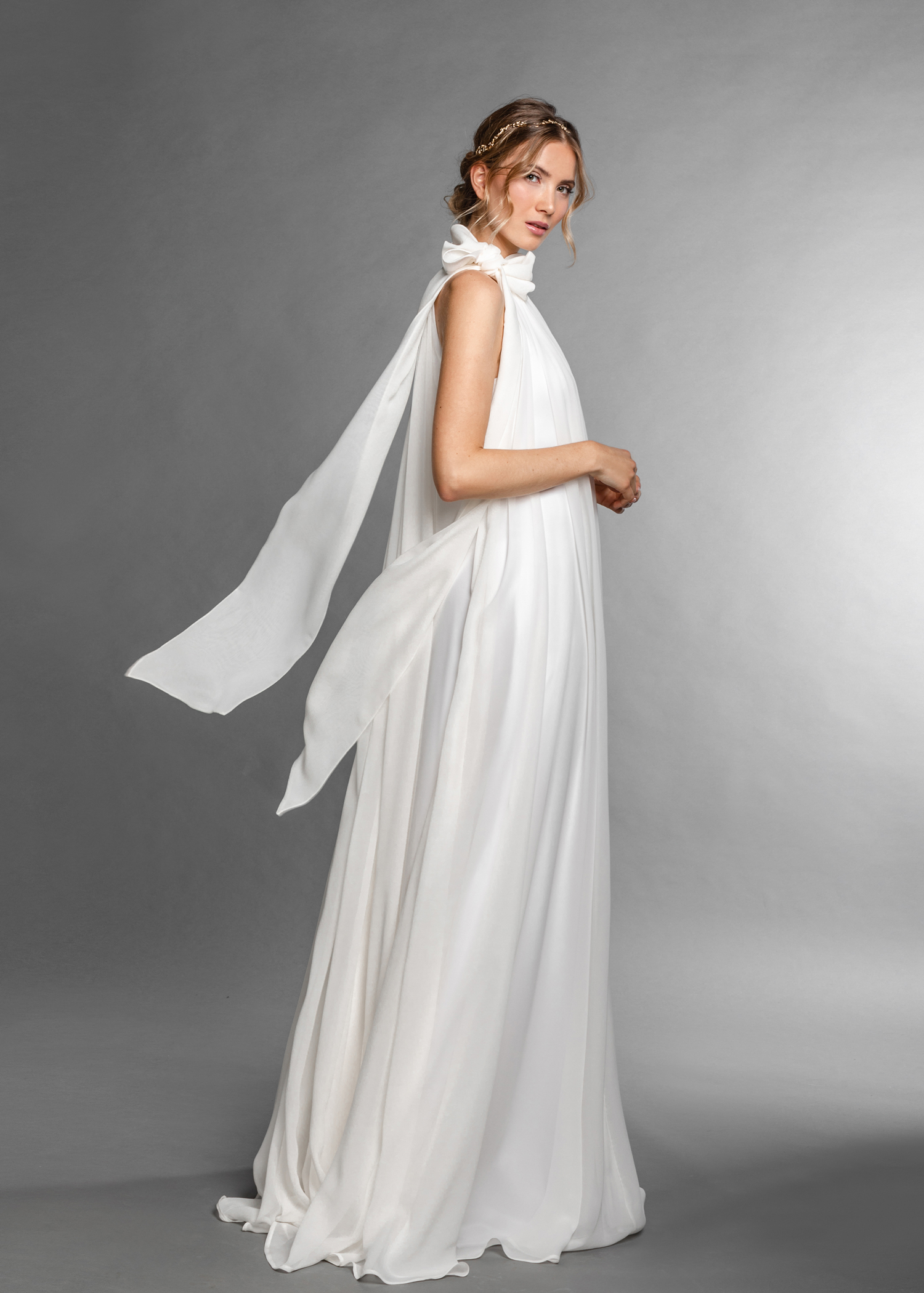 Hochzeitskleider Ein wallendes Brautkleid mit feinem fallenden Stoff an einer Frau mit blondem Haar